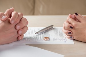 Couple's Hands Signing Papers to Update Estate Plan